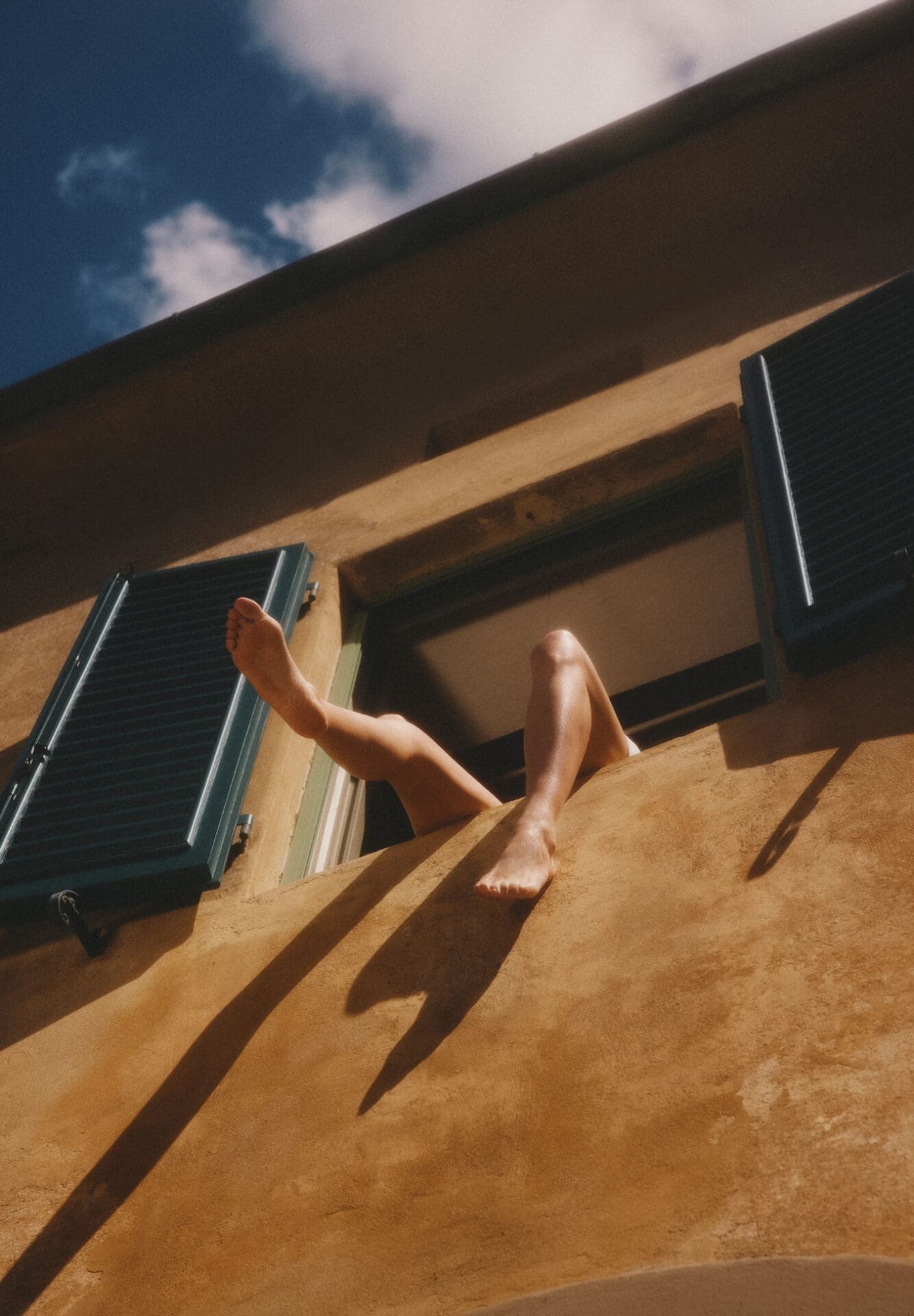 A legs of women hanging out from window